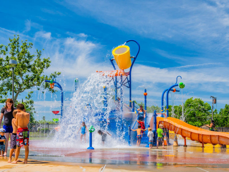 Excited children playing together at White Rock Splash Park, enjoying the various water play features.