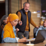 young-woman-taking-notes-in-meeting-grey-rocking