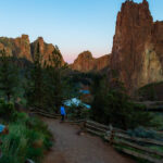 A hiker looking out at Smith Rock State Park at sunrise