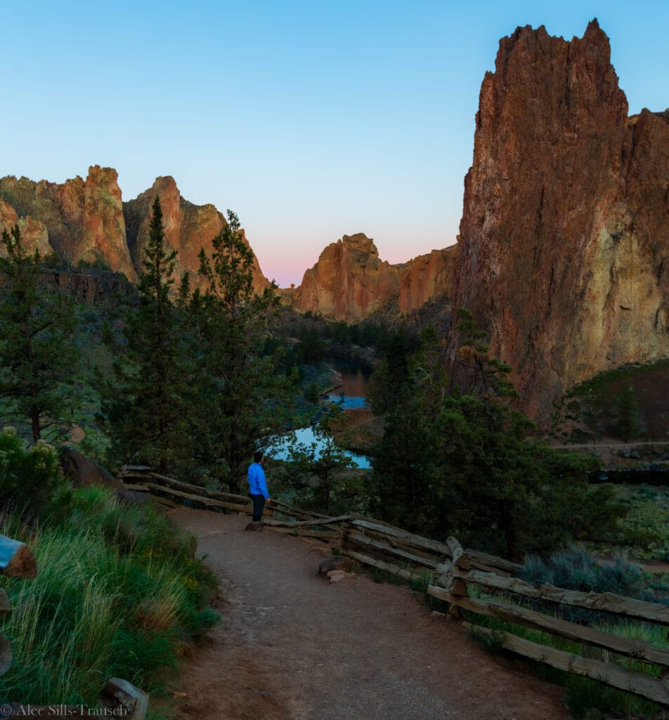 A hiker looking out at Smith Rock State Park at sunrise