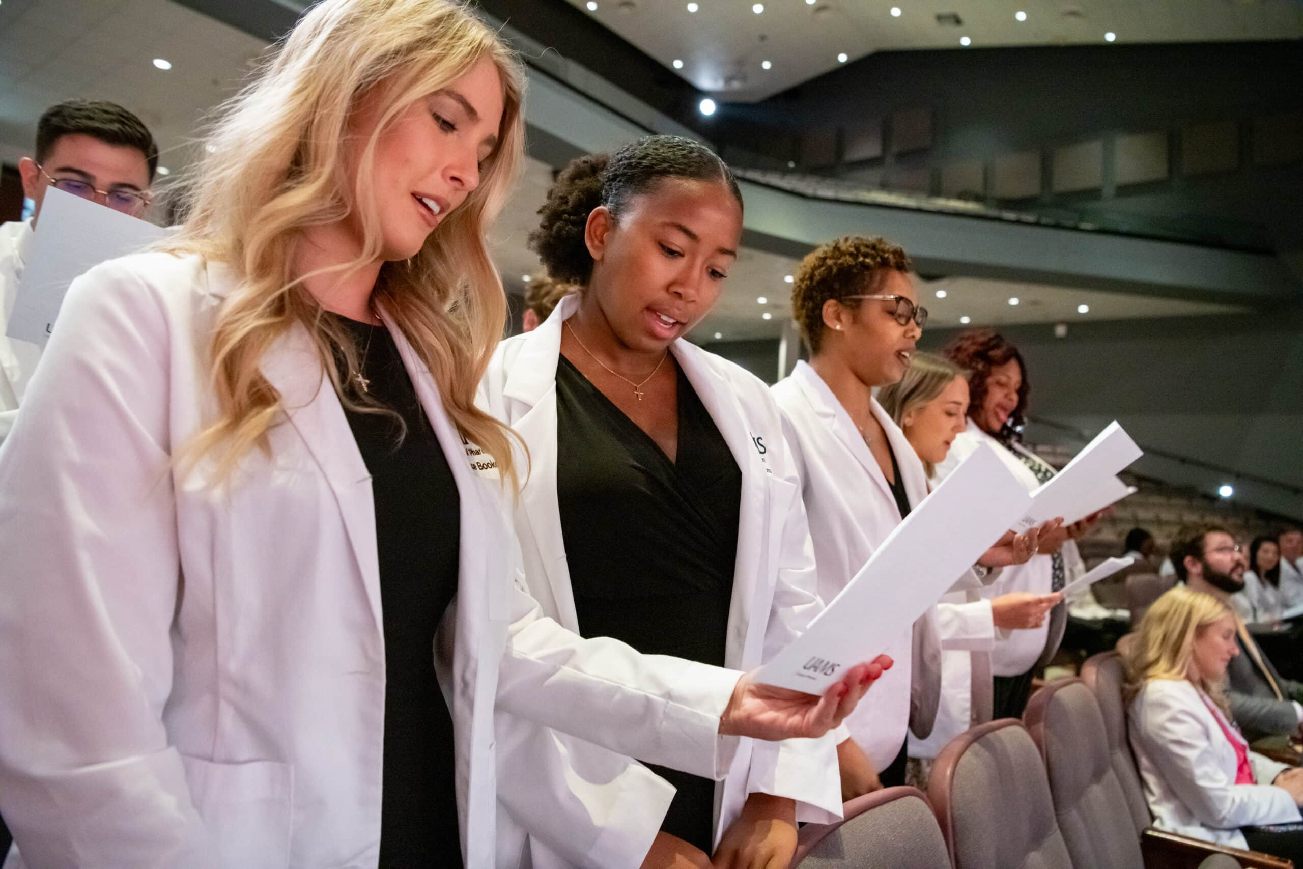 Grace Booker, Kennedi Burns, Kia Bursey-Walker reciting professionalism pledge, symbolizing new pharmacists commitment to patient care