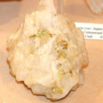 Gold ore specimen with visible gold flecks embedded in quartz matrix