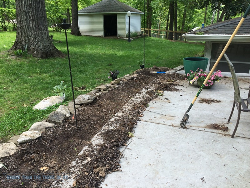 Landscape fabric being installed in a garden bed