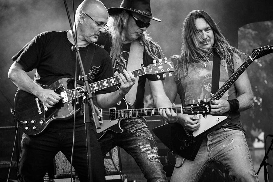 Rock band performing on stage, focusing on the guitarists