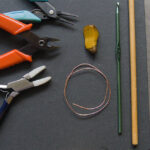 Tools and materials for wire wrapping, including pliers, wire, and various stones