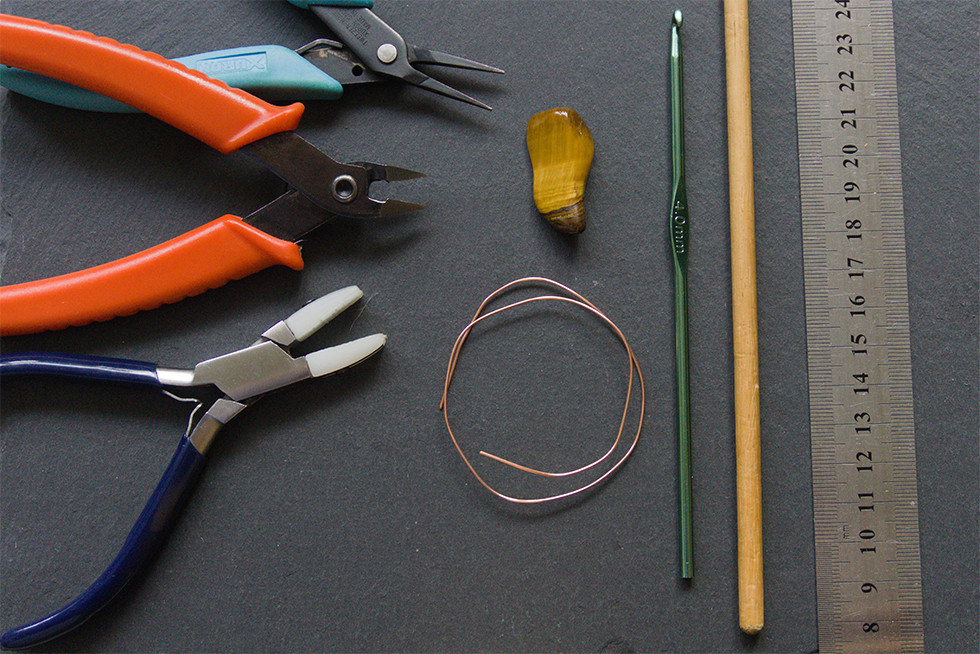 Tools and materials for wire wrapping, including pliers, wire, and various stones