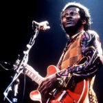 Fats Domino playing piano with his signature style, blending boogie-woogie with blues and R&B elements