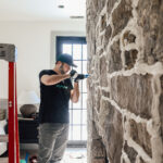 Applying mortar to stone for a fireplace wall