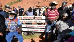 Aboriginal elders gather for a ceremony ahead of a permanent ban on climbing Uluru