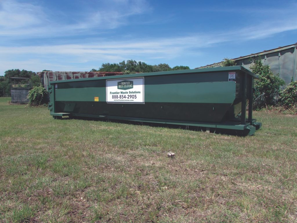 Roll-off dumpster filled with rocks for disposal
