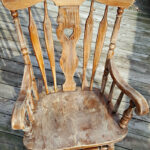 Sanding the rocking chair to prepare the surface for painting.