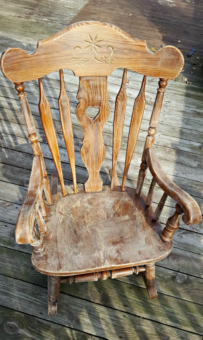 Sanding the rocking chair to prepare the surface for painting.