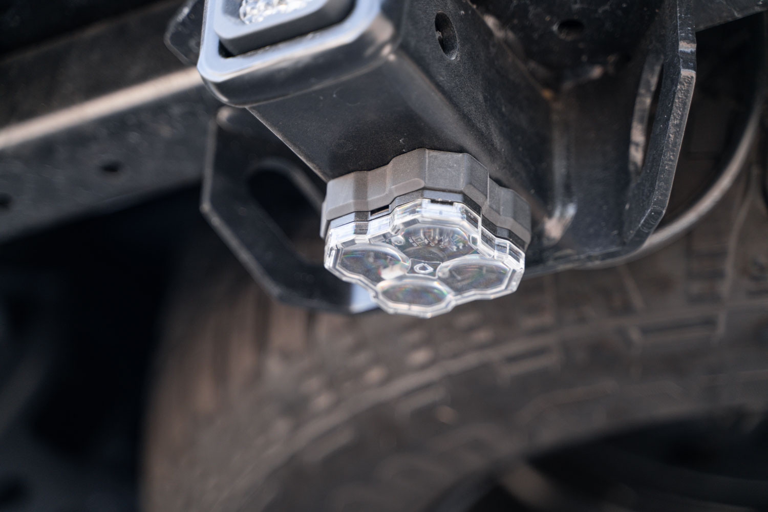 Magnetic-mounted rock light attached to a trailer hitch for easy installation and removal