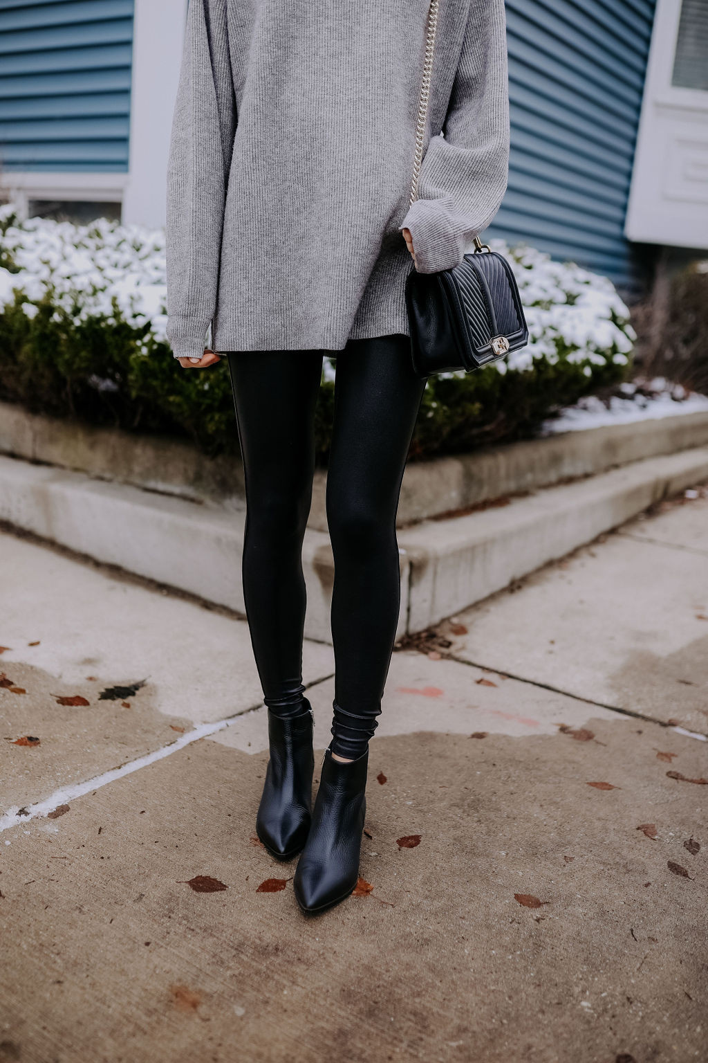 Woman wearing Spanx faux leather leggings with an oversized sweater, highlighting a figure-flattering outfit choice