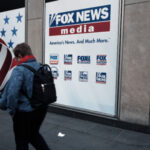 People walk by the News Corporation headquarters, home to Fox News, on April 18 in New York City