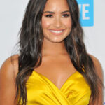 Demi Lovato at WE Day California 2017, addressing a crowd with a microphone