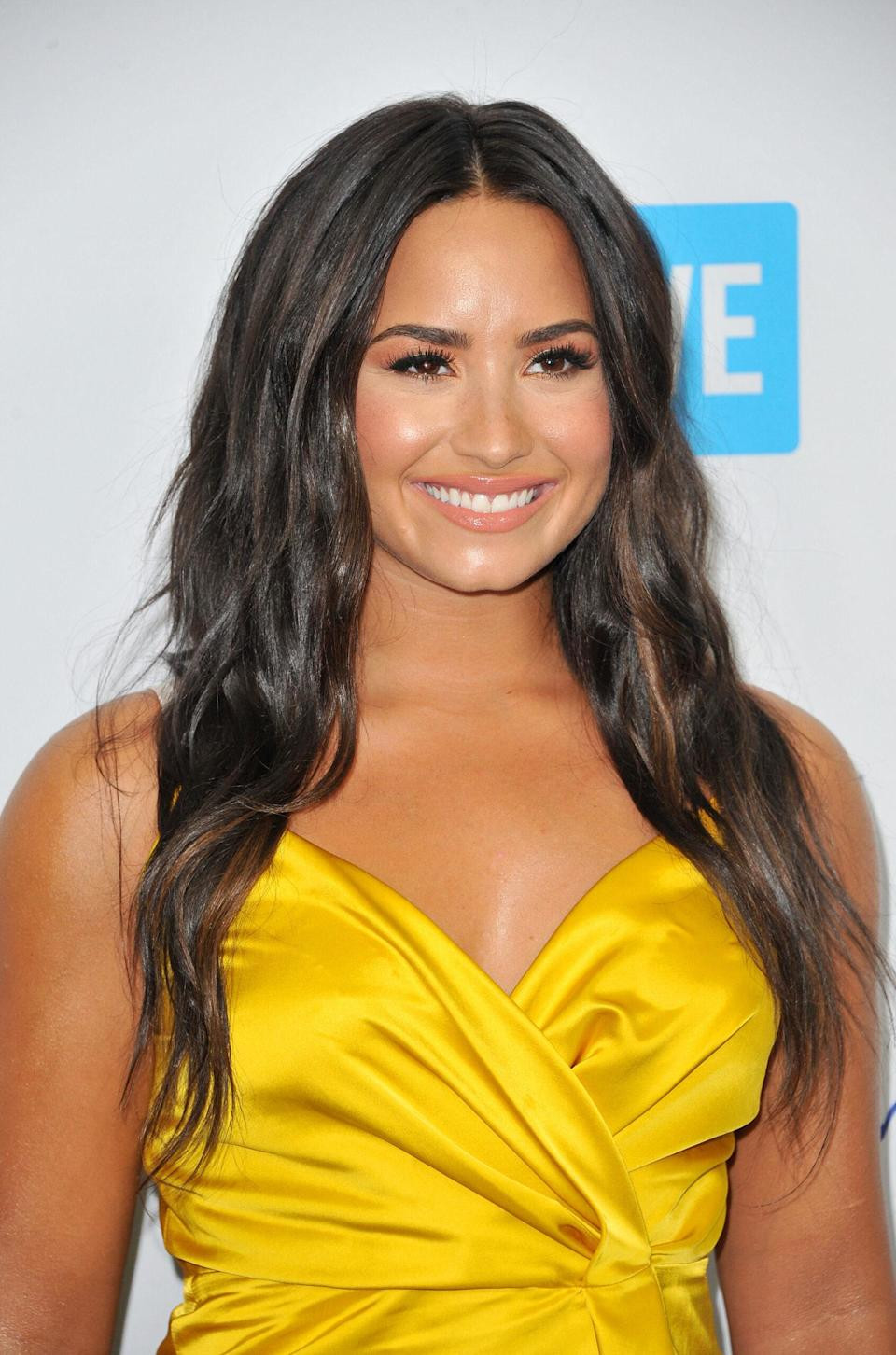 Demi Lovato at WE Day California 2017, addressing a crowd with a microphone