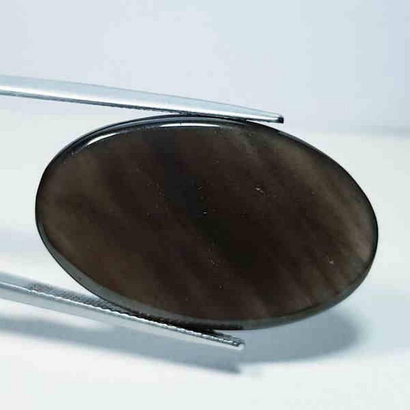 Black obsidian cabochon with a smooth, polished surface