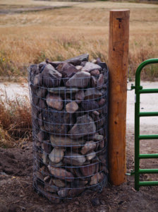 Attaching the gate post to the rock fence, showing the integration of structural and design elements
