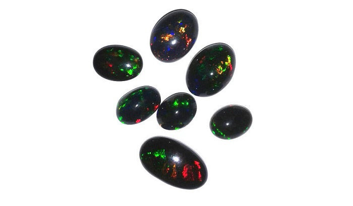 Black Opal gemstone, highlighting its dark body tone and vibrant play of color, primarily sourced from Lightning Ridge, New South Wales, Australia.
