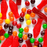 Close-up of vegan sour gummy candies, highlighting the texture and sugary coating, showcasing a plant-based alternative to traditional gelatin-based gummies. These candies offer a tasty and ethical option for those following a vegan lifestyle, with a sweet and tangy flavor.