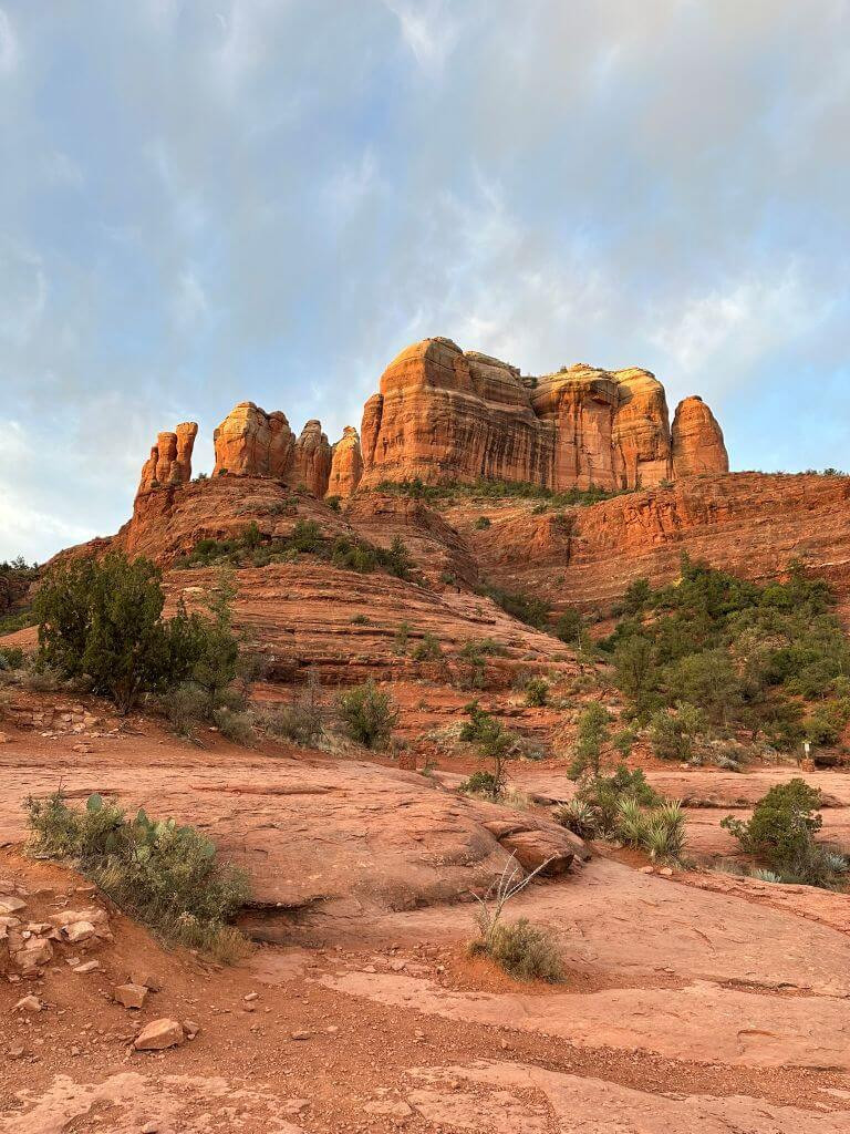 The open red rock stretch of Cathedral Rock Trail, with rock cairns marking the way