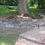 Rock wall enhancing garden with lush plantings