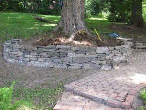 Rock wall enhancing garden with lush plantings