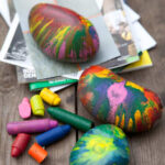 Collection of easy crayon rock paper weights featuring colorful melted crayon designs.