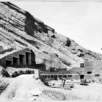 Photograph of George Cranmer, Denver's Parks and Improvements Manager, standing near the Red Rocks Amphitheatre construction site, showcasing his involvement in the project's development.