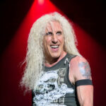 Dee Snider of Twisted Sister in full makeup and hair, holding a microphone, performing on stage