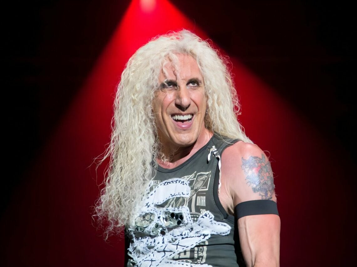 Dee Snider of Twisted Sister in full makeup and hair, holding a microphone, performing on stage