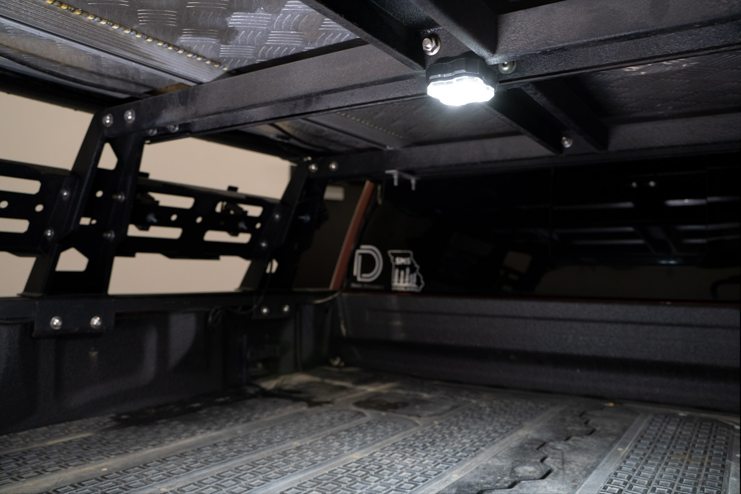 Rock light mounted in the cargo area of a truck bed