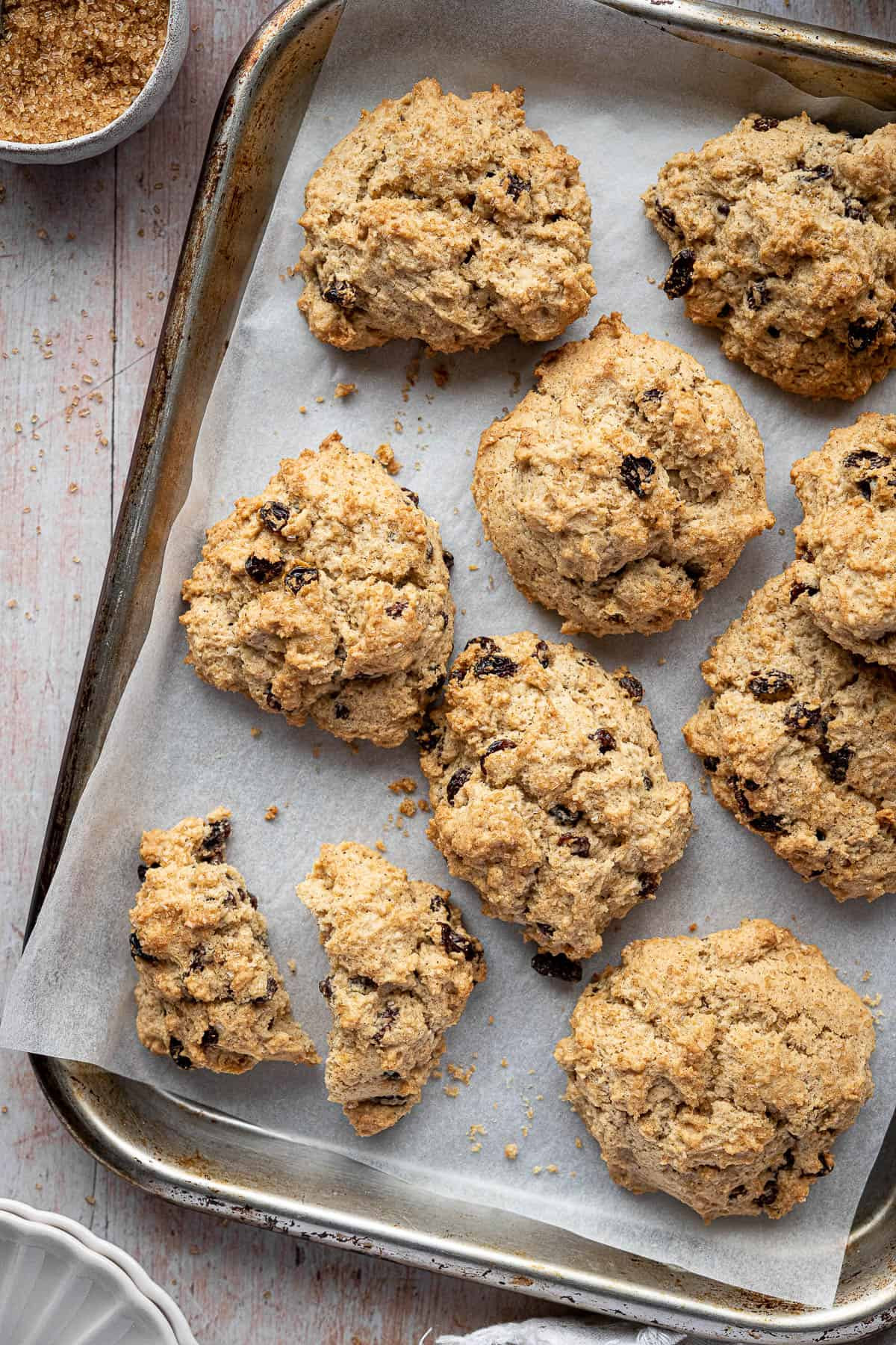 An image of rock cakes arranged on a plate with a cup of tea, showcasing a cozy, inviting setting.