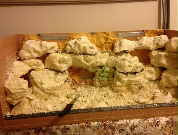Carving polystyrene foam to create a fake rock wall