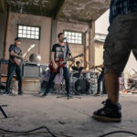 Rock band members collaborating on songwriting in a rehearsal space, showcasing teamwork and creativity