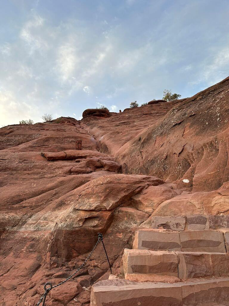 Hikers navigating a rock scrambling section on Cathedral Rock Trail, demonstrating the need for agility and balance