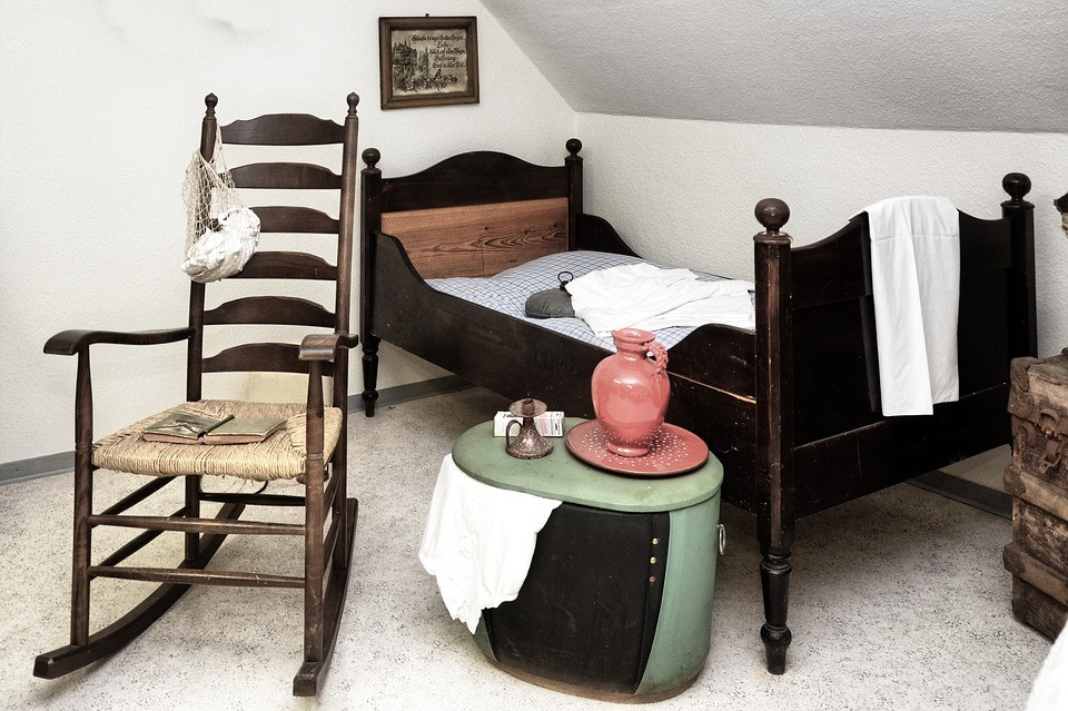 history of rocking chairs - old rocking chair with bed, trunk and old pottery