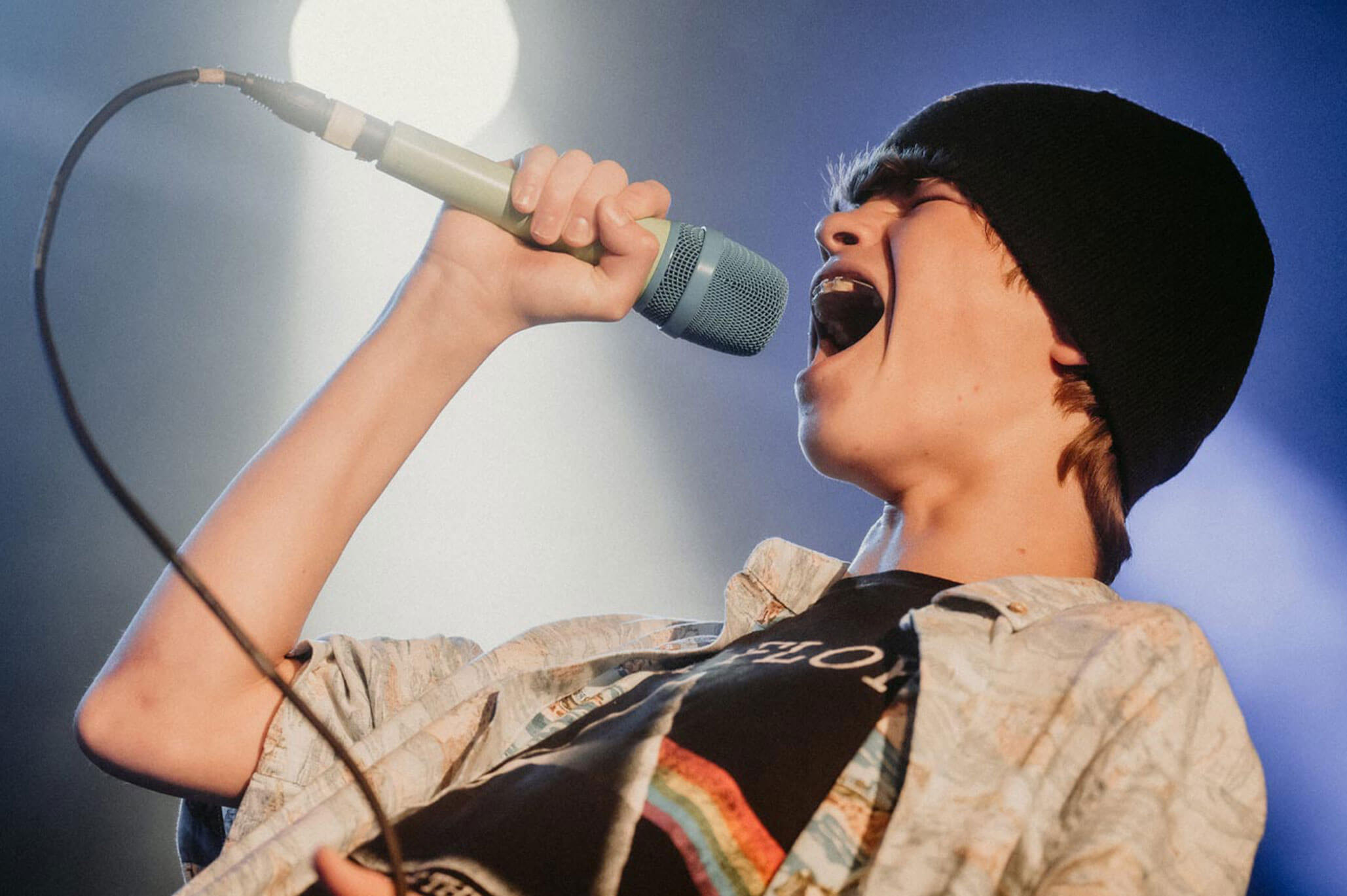 A kid vocalist singing with rock style