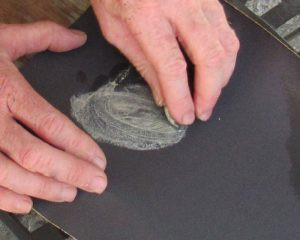 Shaping a rock with coarse sandpaper