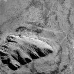 Uluru or Ayers Rock, a monolith in central Australia, captured by ESA's Proba microsatellite, showcasing its reddish hue and the surrounding flat desert landscape