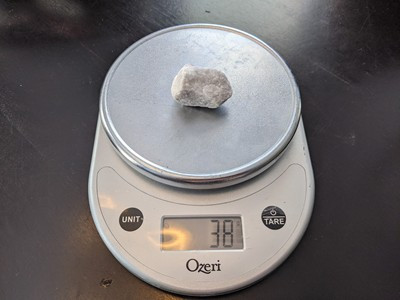 Landscaping rock on a scale, confirming its approximate weight of 40 grams