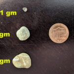 Pebbles next to a penny for scale, illustrating their individual weights