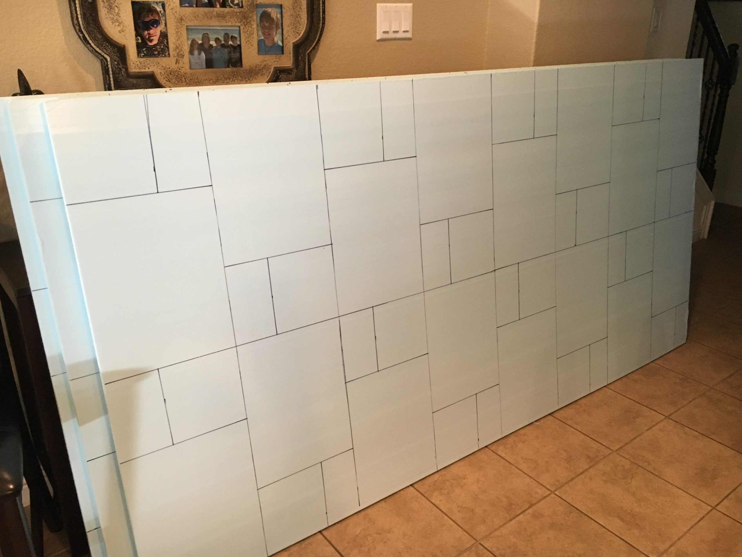 Cutting foam sheets into stone shapes with a hot wire cutter for creating realistic faux rock features.