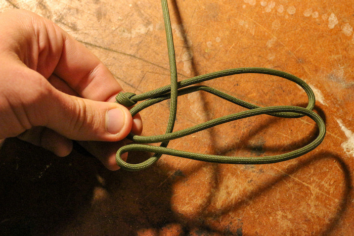 Hold onto the base of your loops, take the long end of your paracord and bring it under the bottom loop, and over the top loop.