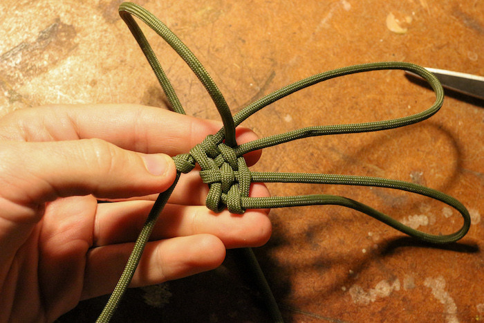 Making a few passes, pull your weaves tight against your original overhand knot. This will keep your pouch weave tight, and make it easier to hold everything together.