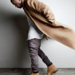 Kanye West wearing Timberland boots with a coat