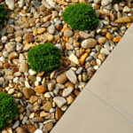 Landscaping rock with weeds growing through, showing the aesthetic problem of weeds in rock gardens