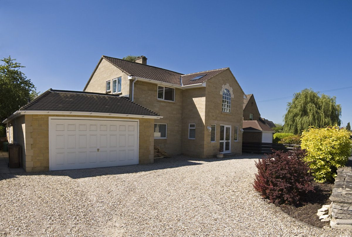 Crushed Stone Driveway Leading Up to Two-Story Residential Home 
