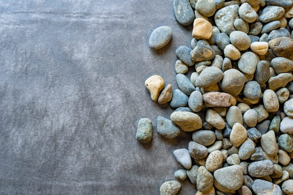 Nonwoven landscape fabric separating drain rock from the ground